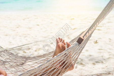 泰国海女人在海滩的吊床上放松背景