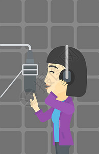 一名戴耳机在录音室唱歌的女歌手图片