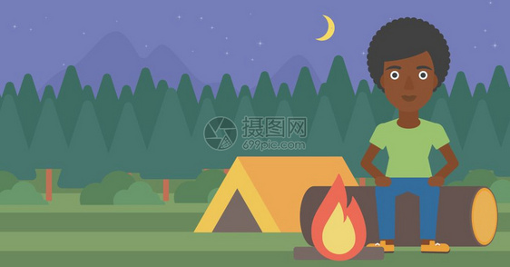 一名坐在露营地篝火旁的非裔女子图片