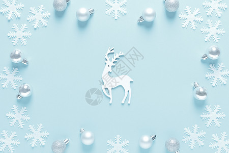 圣诞节新年或日冬季贺卡彩球鹿和蓝底雪花平的固定构成顶视图片
