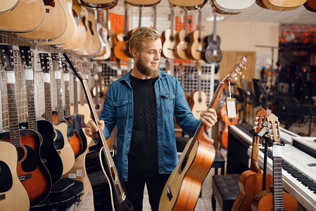 音乐店的吉他选手音乐器店的组合男音乐家购买设备工具高清图片素材