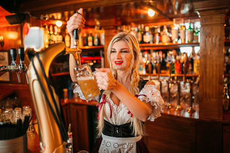 女服务员在酒吧柜台倒啤酒背景图片