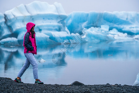 女探险家在阿拉斯加冰岛沙滩行走图片