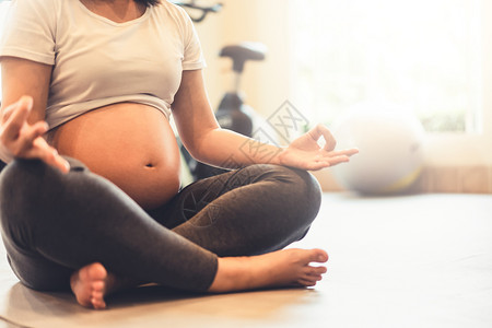 孕妇做瑜伽运动孕妇在健身房做瑜伽和冥想背景