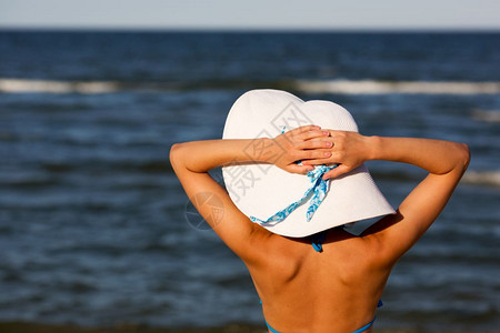 戴着大帽子的性感女孩在沙滩上放松图片