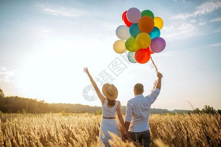 美丽的妻子和丈夫在夏季草地上行走图片