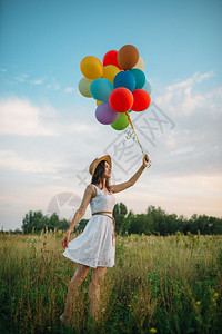美女在草原上手牵气球微笑图片