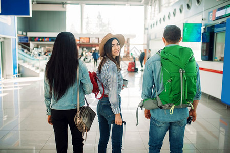 携带行李的3名旅客在机场等待图片