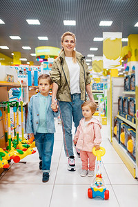 母亲与女儿和儿子一起在超市选择玩具图片
