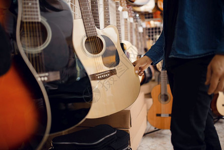 男客户在音乐店选择响吉他乐器店购买设备主人高清图片素材