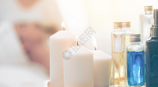 芳香按摩油润滑剂蜡烛和香草提取液放在按摩床上背景图片