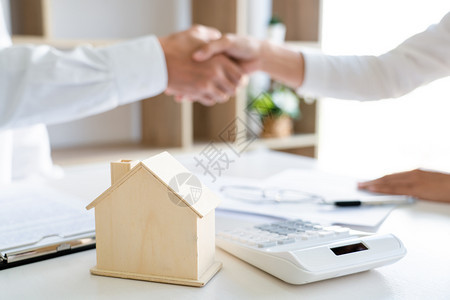 房屋开发商和客户在完成购买后握手合同高清图片素材