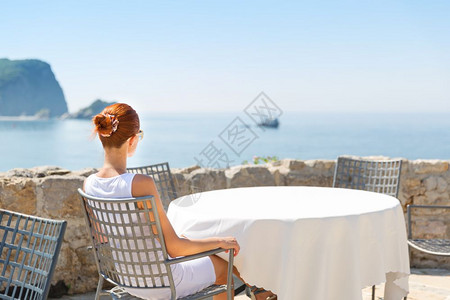 女性坐在蒙泰格罗豪华酒店前海边露台看风景高清图片