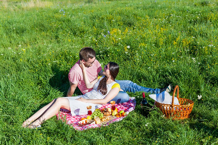 在草地上野餐的年轻情侣图片