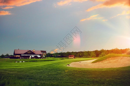 日落时在体育俱乐部的绿色草地为比赛操场高尔夫球发射点修剪草坪图片