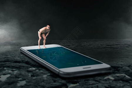 游泳运动员准备跳进游泳池由大型电话屏幕制作总是接触或在线的概念社交者图片