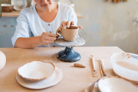 女陶瓷罐车间妇女制作碗手工陶瓷艺品用粘土制作的餐具女陶瓷炉车间图片