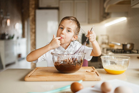 快乐的小孩在吃碗里的巧克力图片