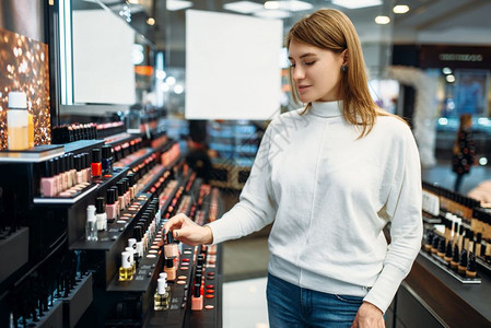 在化妆品店挑选唇膏的女顾客图片