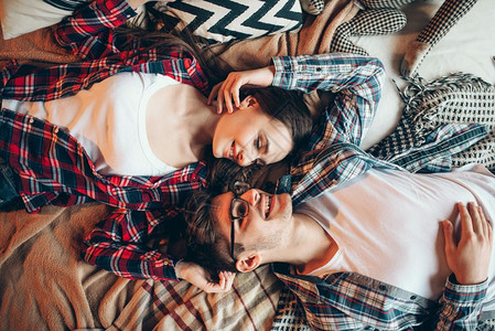 年轻妻子和丈夫在卧室的床上拥抱面的快照图片