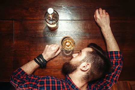 喝醉酒的男人睡在酒吧柜台上图片