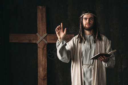 神圣的基督用圣经的手祈祷在黑色背景上祈祷反对圣洁的象征图片
