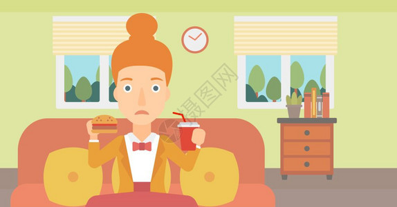 坐在沙发上一边吃汉堡包喝苏打水的时髦女人图片