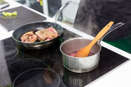 煎锅肉和加酱汁的锅子在家煮肉图片