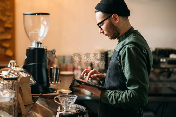 咖啡馆的酒保检查背景模糊图片