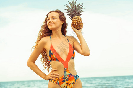 快乐的年轻女子穿着泳衣在夏季热带沙滩上度假图片