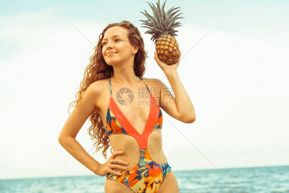 快乐的年轻女子穿着泳衣在夏季热带沙滩上度假图片