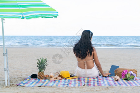 穿比基尼的女子暑假坐在沙滩上热带海旅行生活方式穿比基尼的女子夏天坐在沙滩上图片