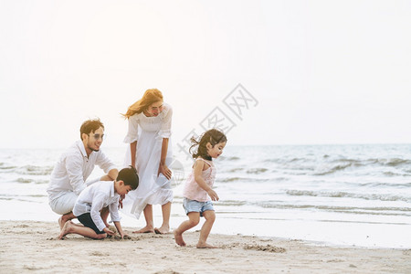 热带沙滩上度假的幸福一家人图片