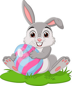 卡通小兔子把复活节鸡蛋放在草地上图片