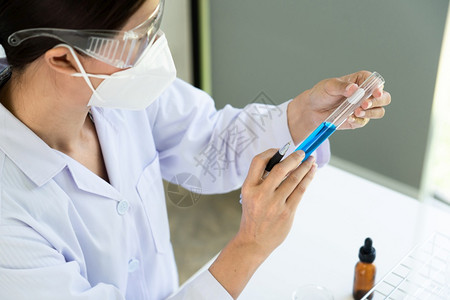 科学家穿戴实验室大衣和防护服从事实验室工作图片
