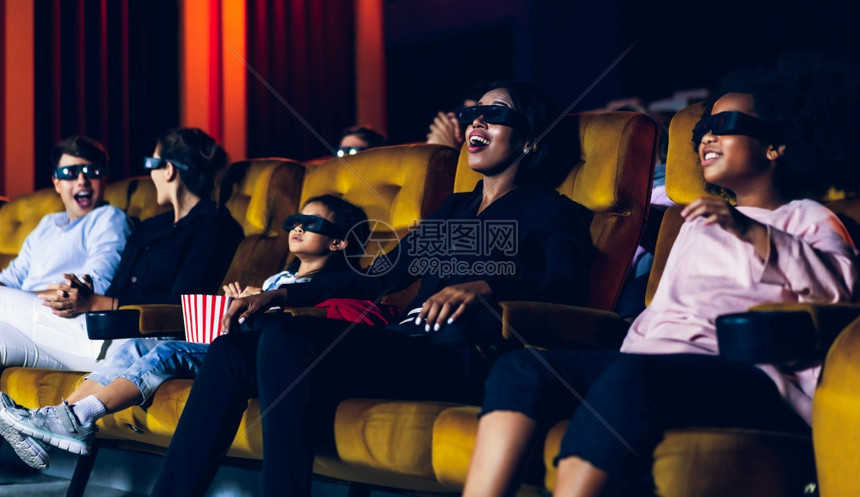 一群人在电影院看带着3d眼镜看电影有兴趣屏幕奋和吃爆米花