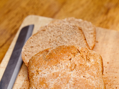 家庭用刀子在面包板上做小麦背景图片