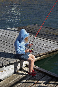 小女孩坐在码头上钓鱼图片