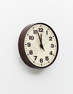 办公室墙上的棕色简单塑料墙钟表和时间用完的概念背景图片