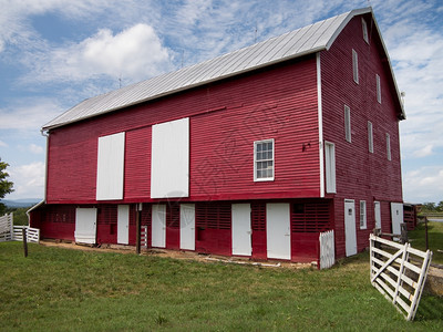 红漆的色木制谷仓在农场上用我们传统风格的白色门图片