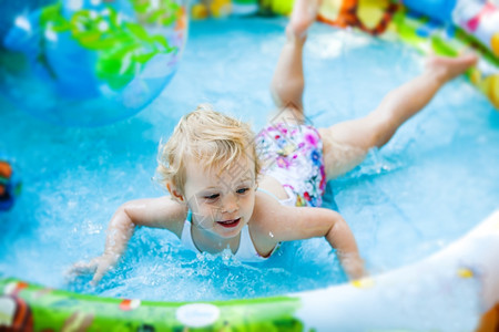 儿童玩玩具在游泳池的小女孩背景