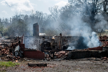 火灾后住宅废墟仍在吸烟背景图片