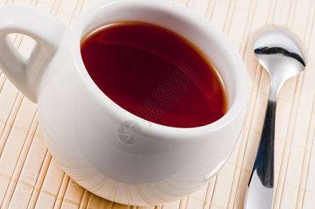 白茶杯木制垫子上有新鲜茶叶图片