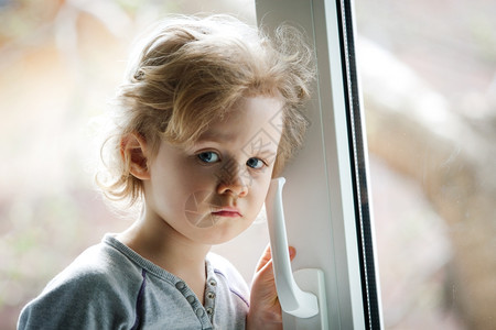 小女孩站在窗边图片