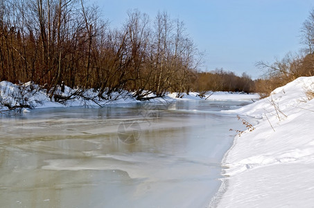 河流雪灌木和树融化的冰雪图片