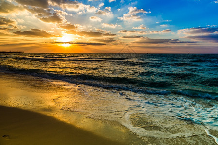 沙滩上美丽的日落惊人颜色光束闪耀在阿拉伯湾海景的云彩中团结阿拉伯酋长国杜拜海和滩图片