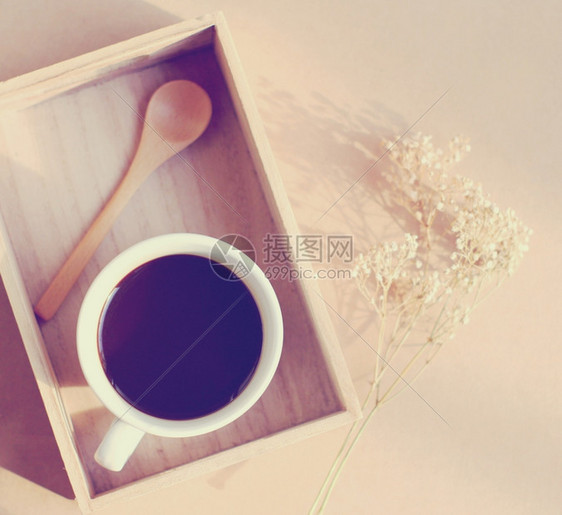 黑咖啡和木板上勺子带干鲜花反转过滤效应图片