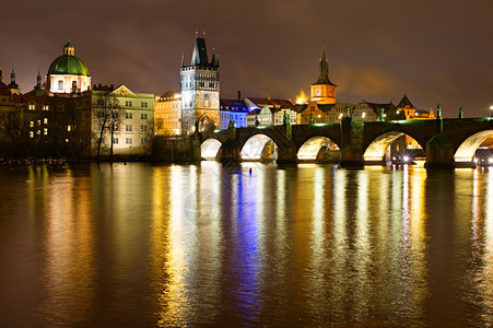 Charles桥和圣弗朗西教堂晚上在Prague举行图片
