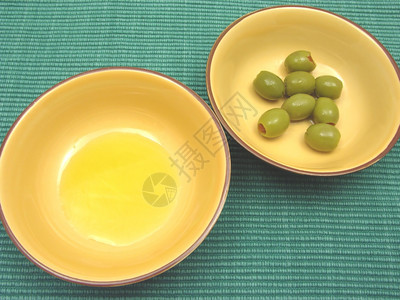 两碗加橄榄油和绿底的陶瓷图片