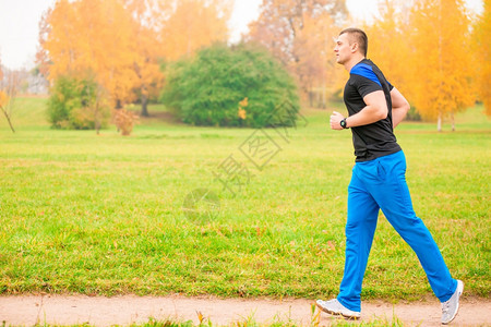 在公园慢跑的男运动员图片